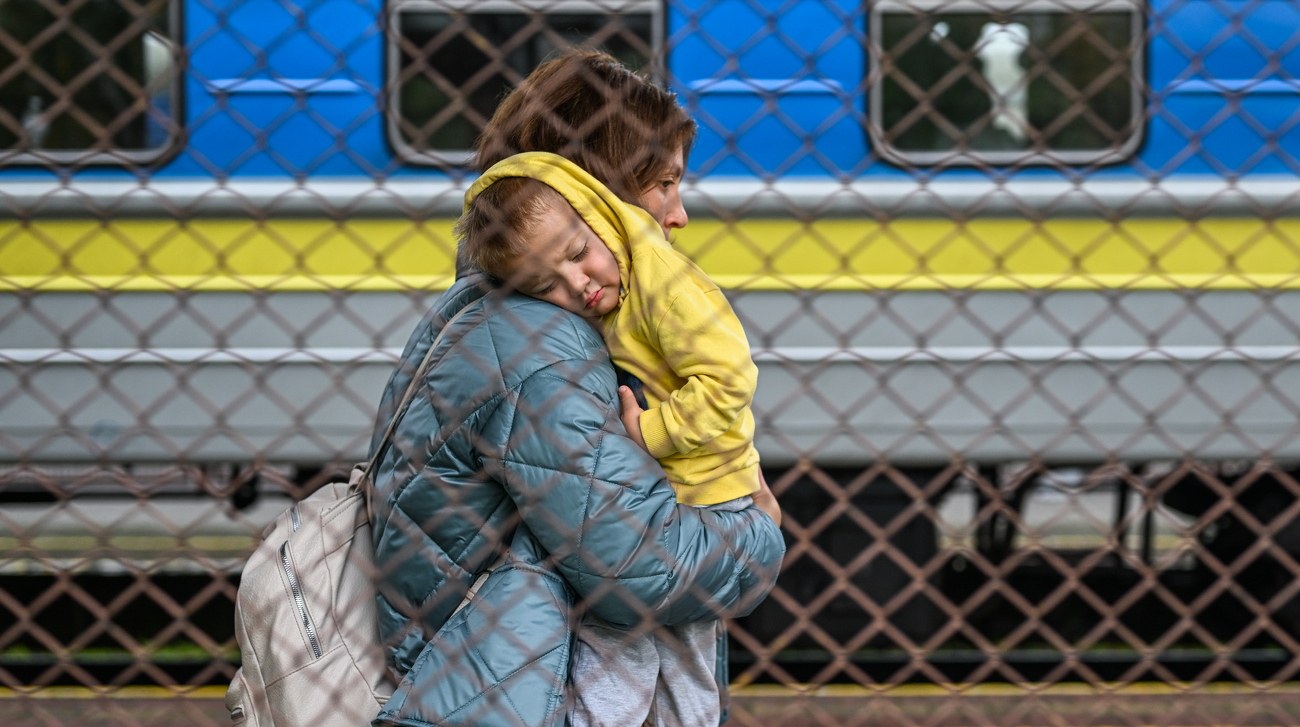 Документи та паспорт зі штампом про виїзд з України на тлі прапорів ЄС та України
