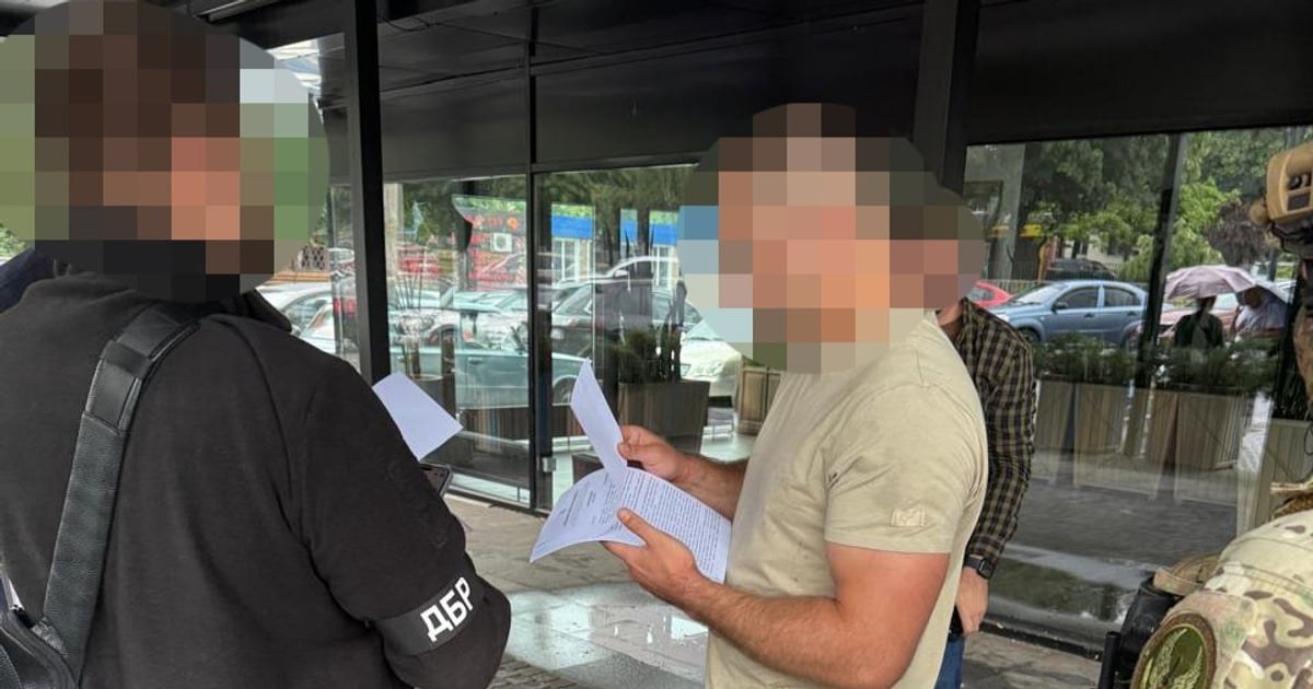 Співробітник ДБР вручає підозру колишньому бійцю полку «Скеля»