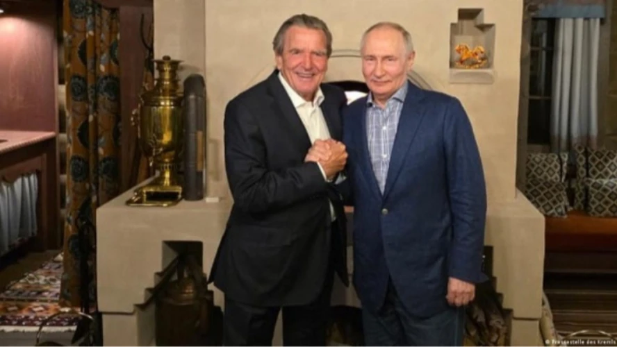 Президент Росії Володимир Путін і колишній канцлер Німеччини Герхард Шредер біля «традиційної російської печі» із самоваром і